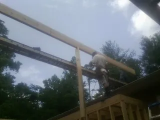 Carpenter setting a ridge beam over a new addition frame — Ice Dam Removal by Roofing Brothers in Runnemede