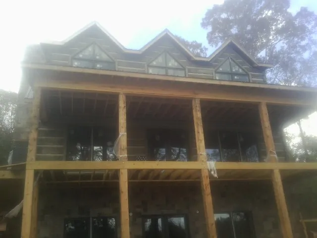Dormers and porch framing on a large log home under construction — Roof Coating work by our crew in Runnemede
